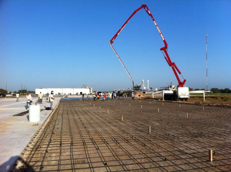Concrete pump truck pouring a large rebar slab