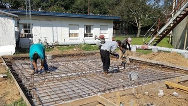 Crew setting rebar for a concrete foundation pour