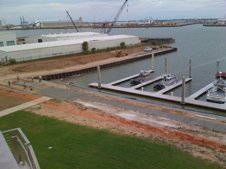 Aerial view of completed waterfront marina with concrete docks and patrol boats